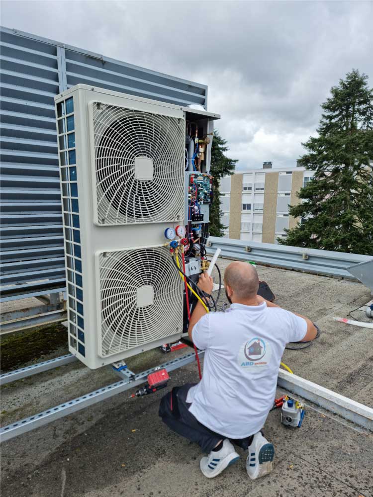 Technicien ABD Énergie en toiture sur une unité de climatisation